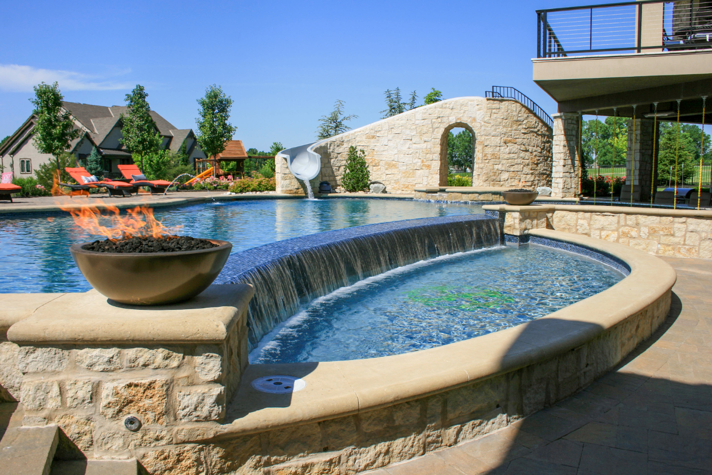 outdoor pool with waterfall, fire elements and slide