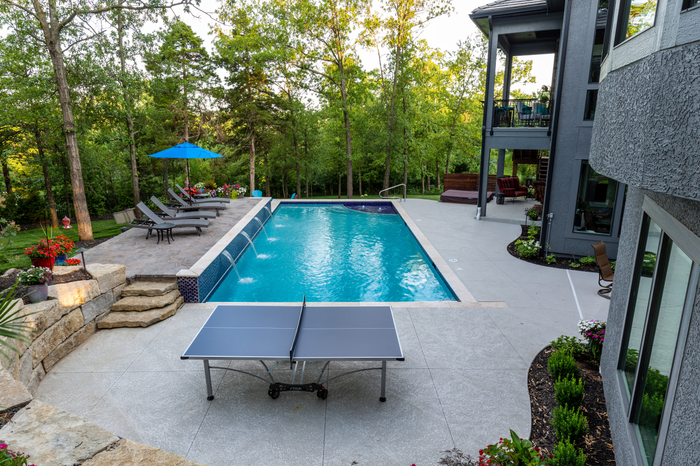 Outdoor pool with waterfalls and ping-pong table