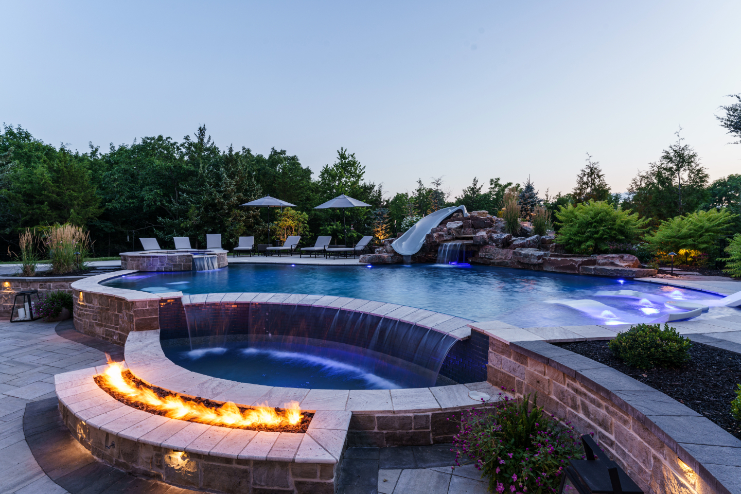 Outdoor pool with slide, waterfall and firepit